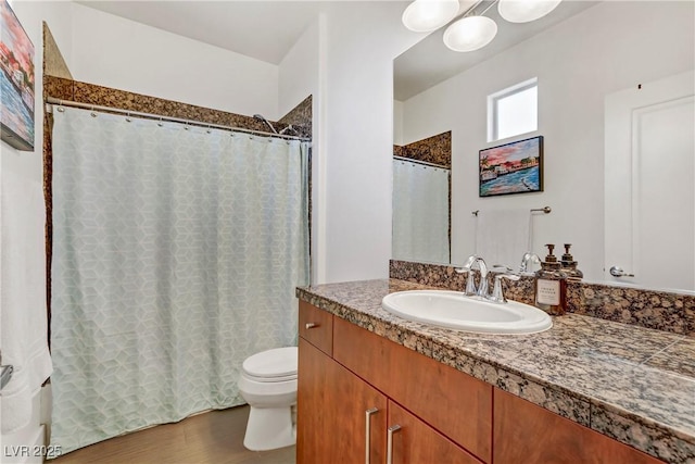 bathroom with vanity, a shower with shower curtain, toilet, and wood finished floors