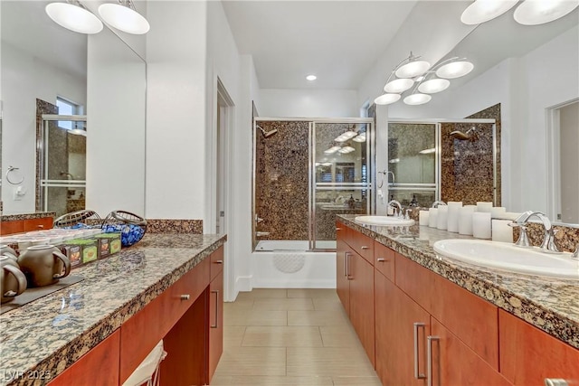 full bathroom featuring double vanity, tile patterned flooring, combined bath / shower with glass door, and a sink