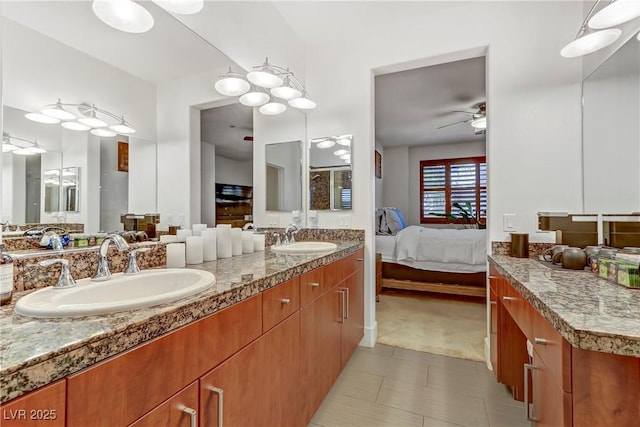 full bathroom with ceiling fan, ensuite bath, double vanity, and a sink