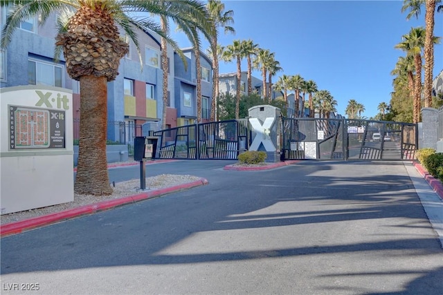 view of street featuring curbs, a residential view, a gated entry, and a gate