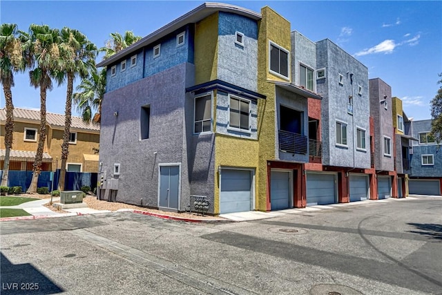 view of building exterior featuring a garage and a residential view