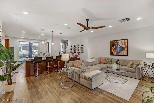 living area featuring recessed lighting, wood finished floors, and visible vents