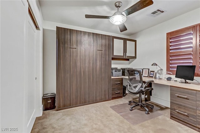 office area featuring a ceiling fan, light colored carpet, and visible vents