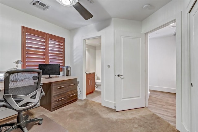 home office featuring light colored carpet, visible vents, and ceiling fan