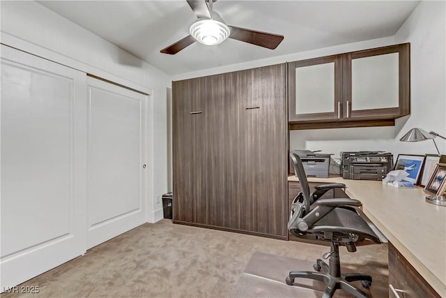 carpeted home office featuring a ceiling fan