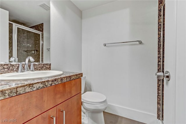 full bathroom featuring vanity, a shower stall, toilet, and visible vents