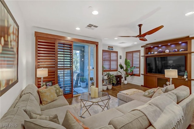 living room with recessed lighting, a healthy amount of sunlight, and wood finished floors