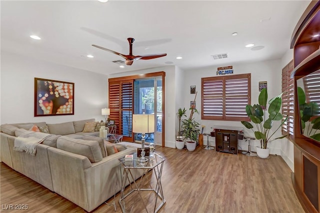 living area featuring visible vents, baseboards, recessed lighting, wood finished floors, and a ceiling fan