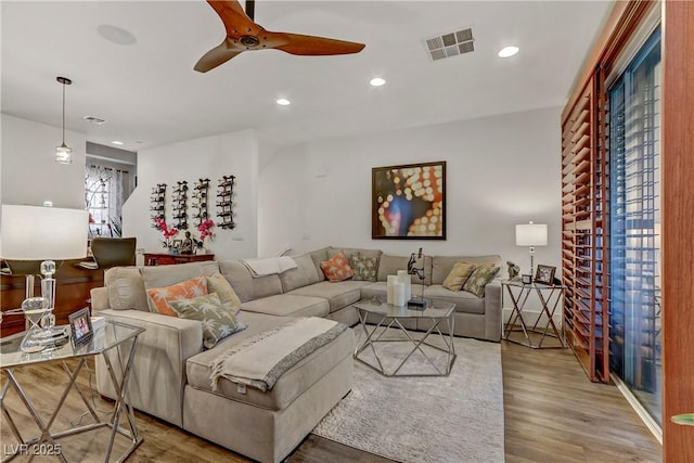 living area featuring a ceiling fan, recessed lighting, wood finished floors, and visible vents