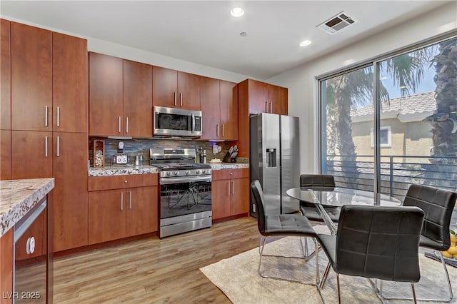 kitchen with visible vents, backsplash, recessed lighting, appliances with stainless steel finishes, and light wood finished floors