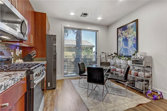 dining room featuring light wood finished floors, visible vents, recessed lighting, and baseboards