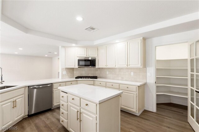 kitchen featuring visible vents, tasteful backsplash, dishwasher, and wood finished floors