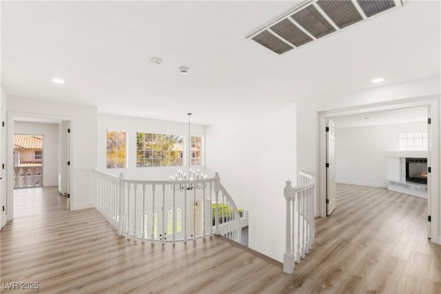 3021 Ocean Port Dr, Las Vegas, NV 89117 - hall featuring visible vents, an upstairs landing, wood finished floors, baseboards, and a notable chandelier