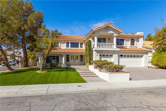 mediterranean / spanish house featuring stucco siding, a front lawn, concrete driveway, a garage, and a balcony