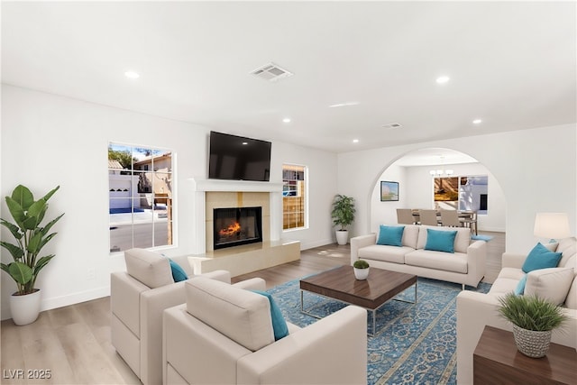 living room with recessed lighting, visible vents, light wood-style flooring, and a fireplace