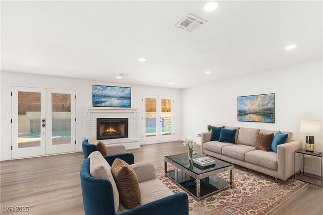 living area with recessed lighting, french doors, light wood-style floors, and visible vents