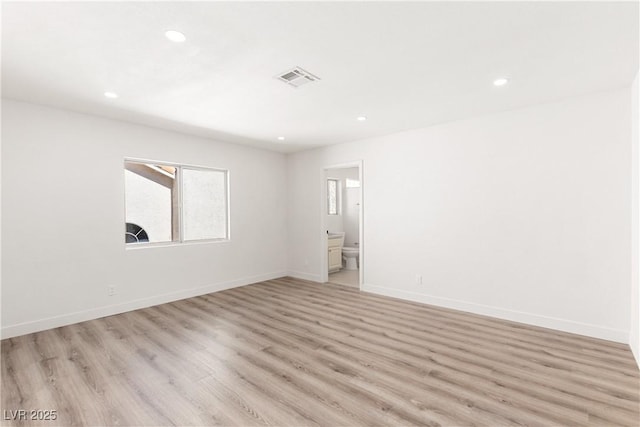 empty room with visible vents, recessed lighting, light wood-type flooring, and baseboards