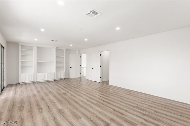 empty room featuring recessed lighting, light wood-style floors, visible vents, and baseboards