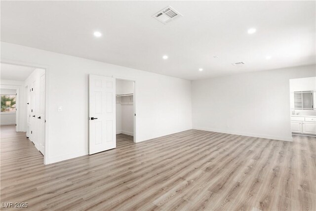 interior space with light wood-type flooring, visible vents, and recessed lighting