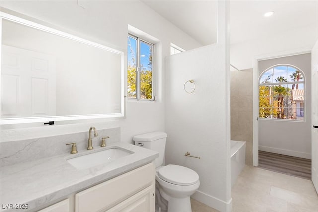 full bathroom with toilet, plenty of natural light, vanity, and baseboards