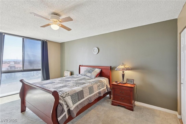 bedroom featuring a textured ceiling, carpet floors, a wall of windows, baseboards, and ceiling fan