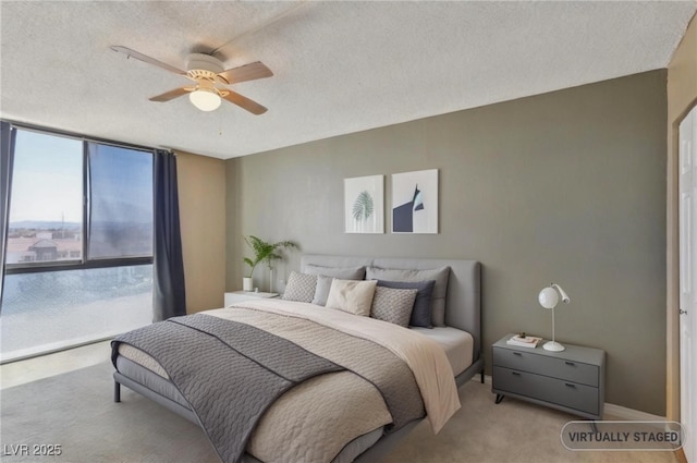 bedroom with a wall of windows, carpet, a ceiling fan, and a textured ceiling