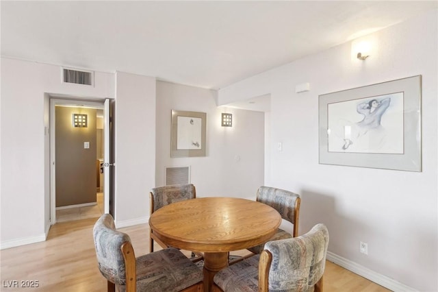 dining area featuring visible vents, baseboards, and light wood-style floors