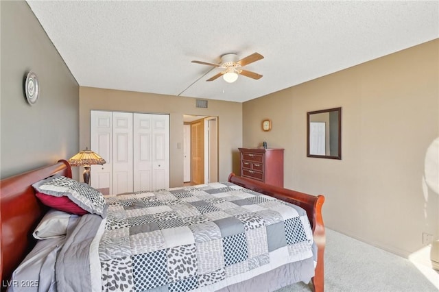 bedroom featuring visible vents, a ceiling fan, a textured ceiling, a closet, and carpet