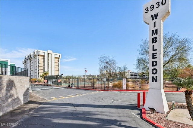 view of road with a gate, curbs, and a gated entry