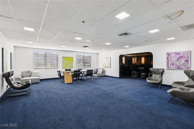 interior space with arched walkways, visible vents, baseboards, and a drop ceiling