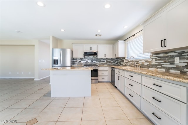 kitchen with a sink, a kitchen island, stainless steel appliances, light tile patterned flooring, and decorative backsplash