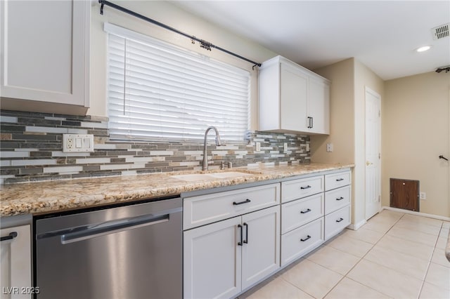 kitchen with a sink, backsplash, stainless steel dishwasher, white cabinets, and light tile patterned floors