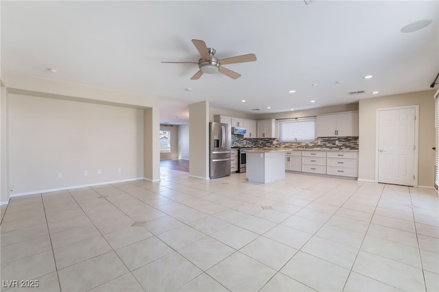 kitchen featuring recessed lighting, stainless steel fridge with ice dispenser, tasteful backsplash, open floor plan, and a center island