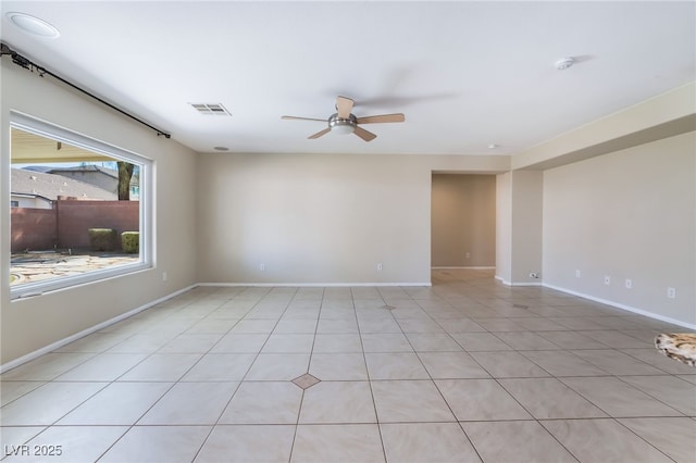 empty room with baseboards, visible vents, and ceiling fan