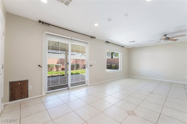 spare room with light tile patterned floors, a ceiling fan, and baseboards