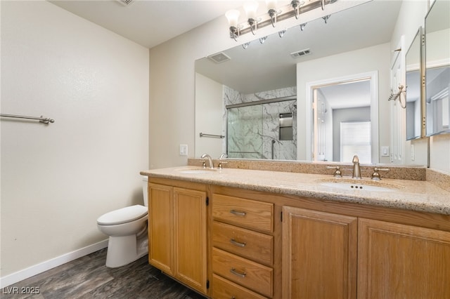 full bath with toilet, visible vents, a marble finish shower, and a sink