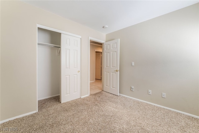 unfurnished bedroom with light carpet, visible vents, a closet, and baseboards