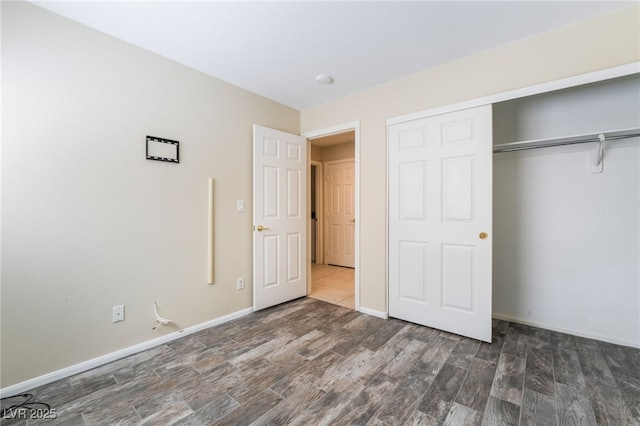 unfurnished bedroom featuring a closet, baseboards, and wood finished floors