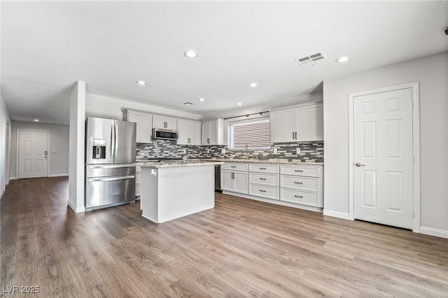 206 Lynbrook St, Henderson, NV 89012 - kitchen with stainless steel appliances, tasteful backsplash, wood finished floors, and recessed lighting
