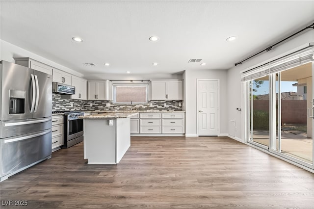 206 Lynbrook St, Henderson, NV 89012 - kitchen with appliances with stainless steel finishes, recessed lighting, decorative backsplash, wood finished floors, and white cabinets