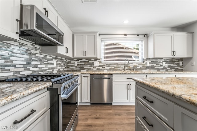 206 Lynbrook St, Henderson, NV 89012 - kitchen with stainless steel appliances, dark wood-style floors, decorative backsplash, white cabinets, and recessed lighting