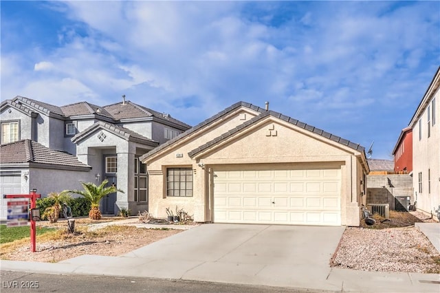 view of front facade with stucco siding, an attached garage, and concrete driveway