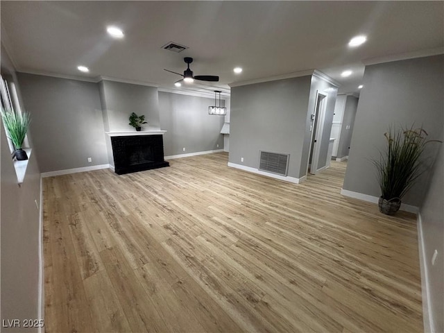 unfurnished living room with light wood-style flooring, a fireplace, visible vents, and ceiling fan