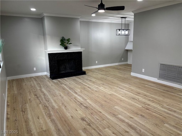 unfurnished living room with ceiling fan, ornamental molding, visible vents, and a premium fireplace