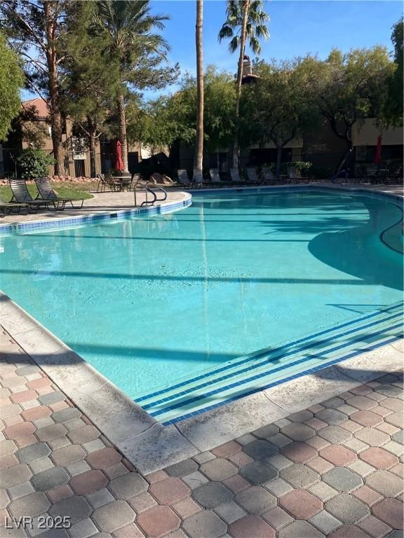 community pool with a patio and fence