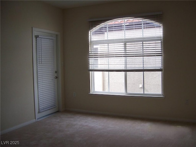 spare room with carpet flooring and baseboards