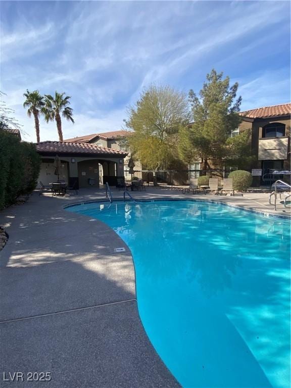 community pool featuring a patio and fence