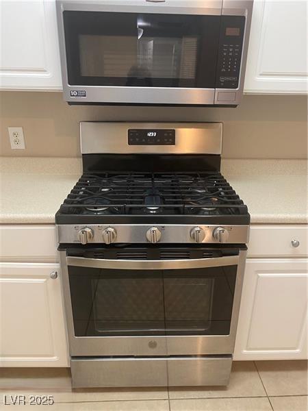 interior details with appliances with stainless steel finishes, white cabinetry, and light countertops