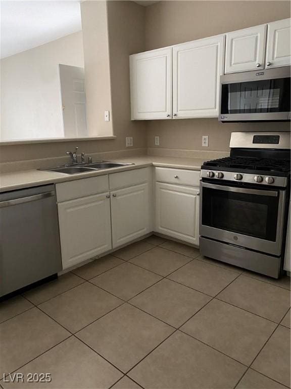 kitchen with a sink, appliances with stainless steel finishes, white cabinets, and light countertops