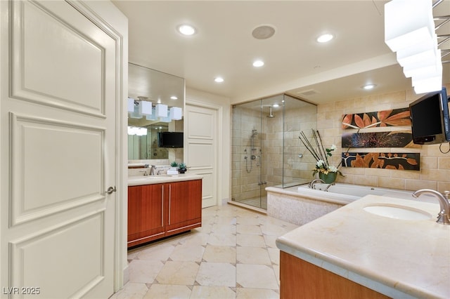 full bathroom featuring a garden tub, two vanities, a stall shower, a sink, and recessed lighting